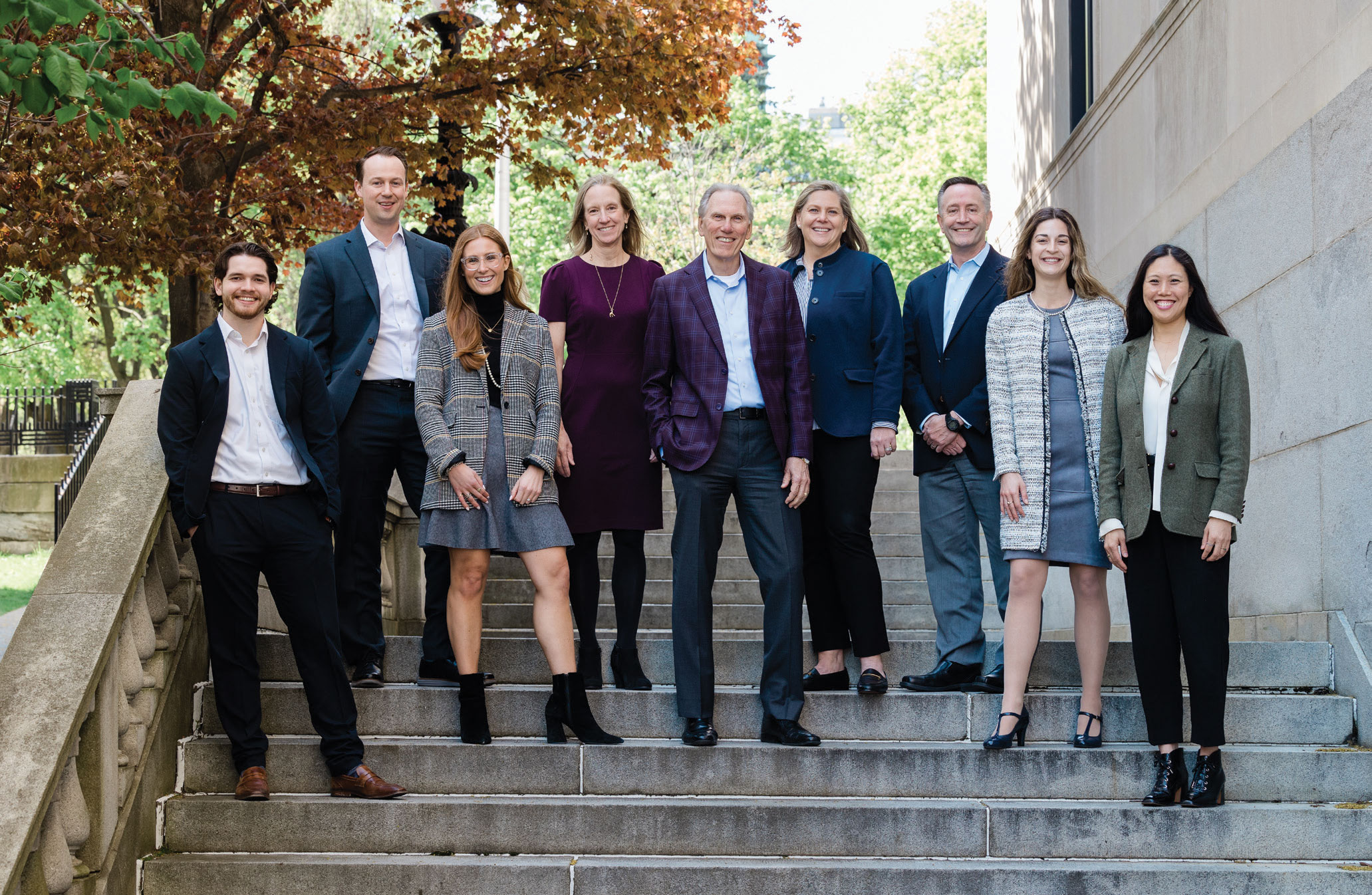 A group of Graypoint advisors stand together on stone steps